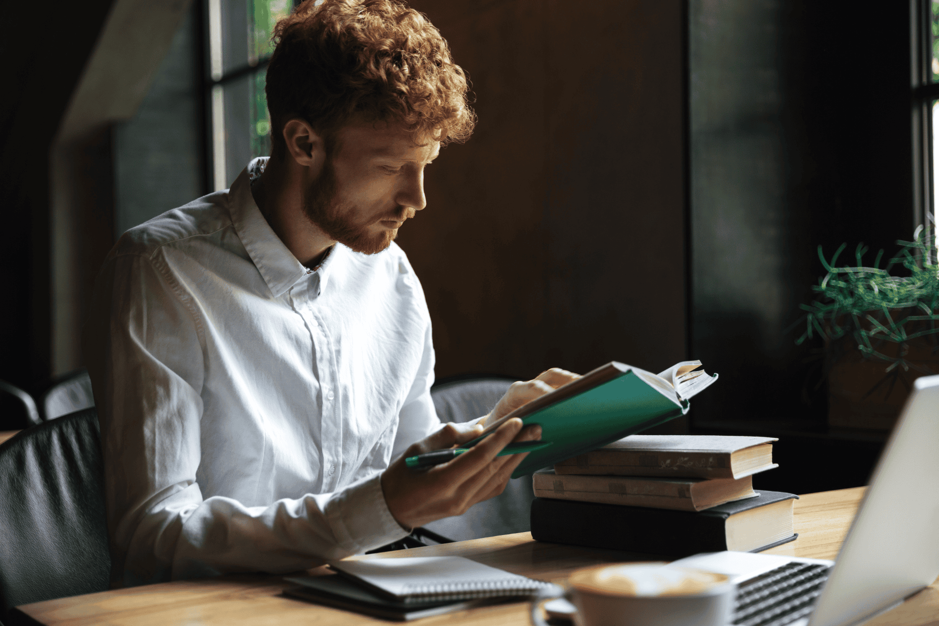 A person reading a book while taking notes