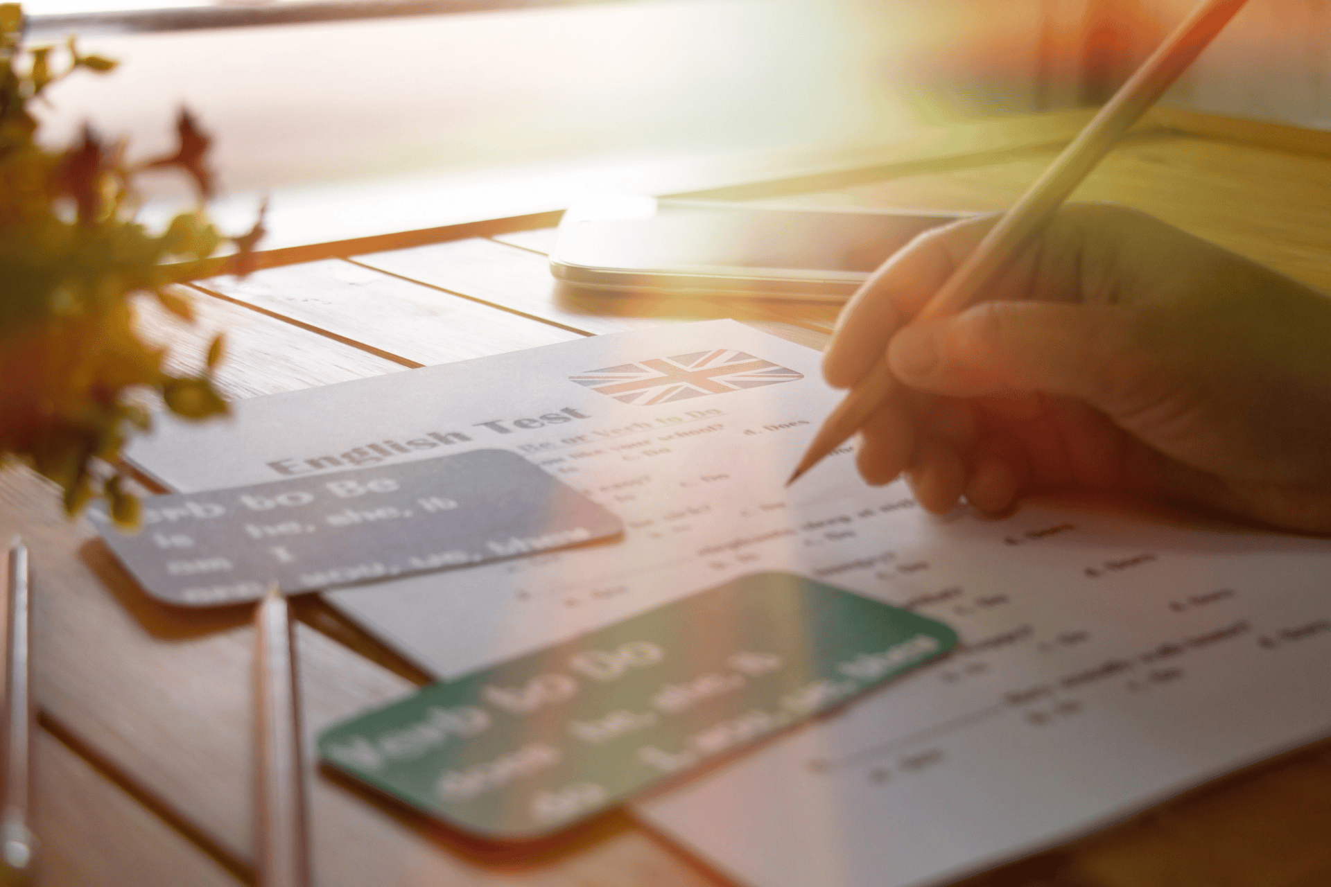 English test on a wooden table, a person holding a pencil to take the test
