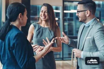 Three business people discussing strategies in an office, focusing on Business English for networking.