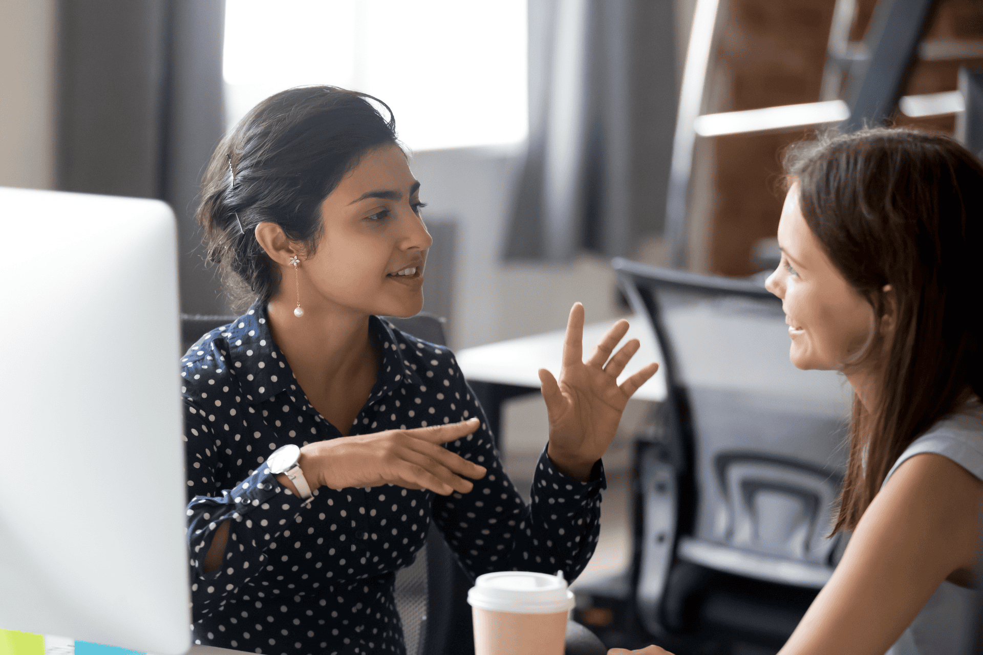 Two women talking to each other at work