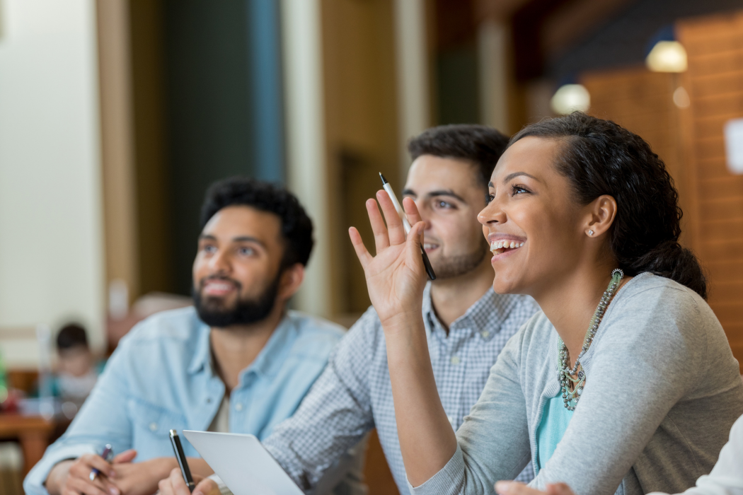 a woman raising her hand in a team meeting
